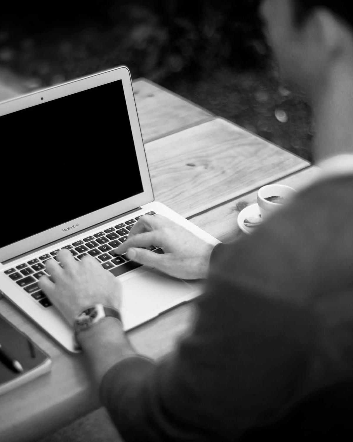An engineer working on a laptop at an outdoor table